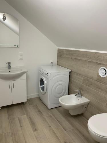 a bathroom with a washing machine and a sink at Nowe mieszkanie w idealnej okolicy in Pabianice