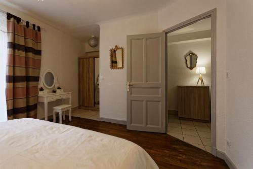 a bedroom with a bed and a bathroom with a mirror at Le cocon d'Eloïse in Verdun