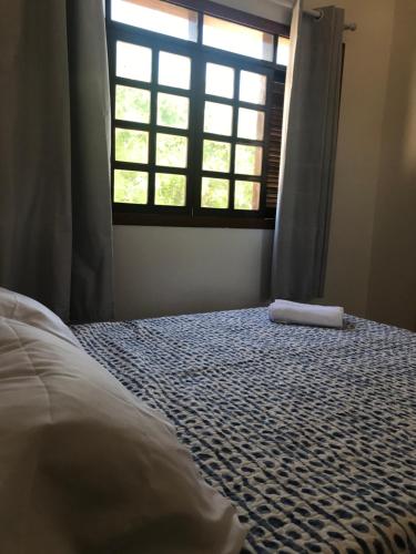 um quarto com uma cama em frente a uma janela em Constancy residence em Itarema