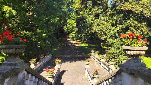 a garden with flowers in vases on a bridge at Pokoje Gościnne Pałac w Balicach Instytut Zootechniki PIB in Balice