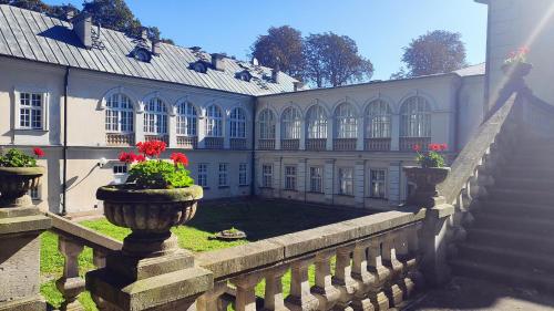 un edificio con dos jarrones con flores rojas. en Pokoje Gościnne Pałac w Balicach Instytut Zootechniki PIB, en Balice