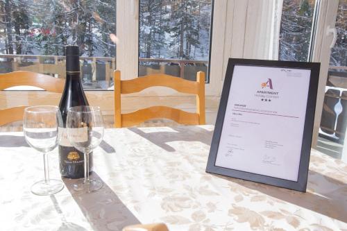 a table with a bottle of wine and a sign on it at Haus Alfa Studios in Saas-Fee