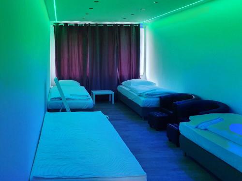a room with three beds and a window with green lights at Graf-Adolflux in Düsseldorf