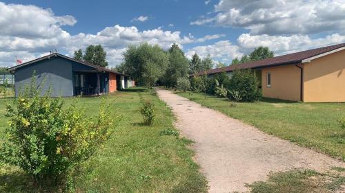 een onverharde weg naast een gebouw en bomen bij AVENTURIER CLUB houses in a line in Rozhny