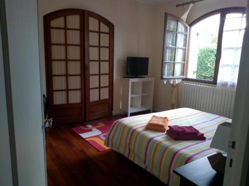Schlafzimmer mit einem Bett, einem Fenster und einer Tür in der Unterkunft L'Orangine in Le Bouscat