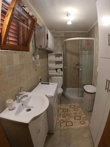 a bathroom with a sink and a toilet and a shower at Katica Nyaraló in Tiszakécske