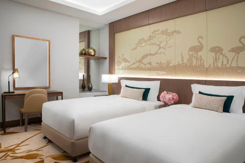 Postel nebo postele na pokoji v ubytování Al Jaddaf Rotana Suite Hotel