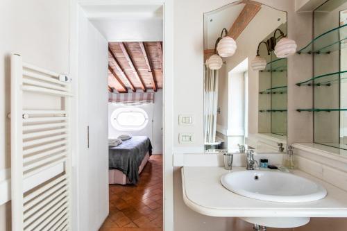 a bathroom with a sink and a bedroom at Frattina Apartments in Rome