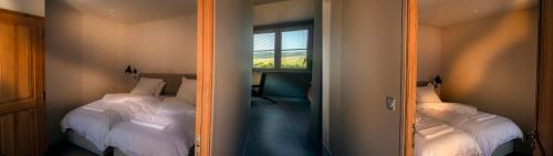 a reflection of a bedroom with two beds and a mirror at The View - Gite Sancy in Montpeyroux