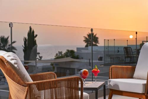 a patio with chairs and a table with a view of the ocean at Mare Paphos in Paphos