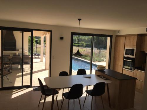 a kitchen and dining room with a table and chairs at Mas Partout in Malaucène
