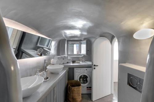 a bathroom with two sinks and a washing machine at I-Sol in Akrotiri