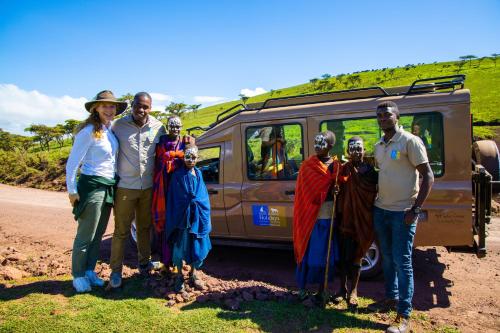 a group of people standing in front of a van at Africa Safari Lake Natron in Mtowabaga