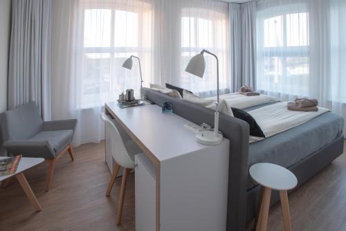 um quarto com uma cama e uma secretária com uma secretária. em Hotel-Restaurant Termunterzijl em Termunterzijl