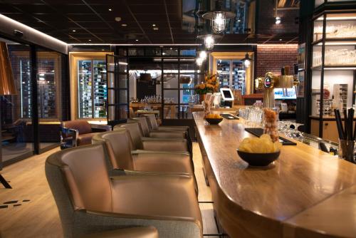 un bar con sillas y una mesa larga en un restaurante en Hotel-Restaurant Termunterzijl, en Termunterzijl