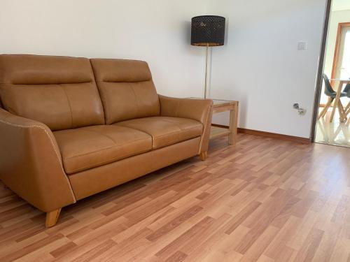 a brown couch in a living room with a table at Enjoy Esmoriz in Esmoriz