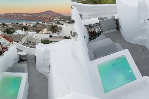 a view of a white house with a swimming pool at Antron Cave House in Akrotiri