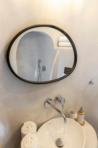 a bathroom with a sink and a mirror at Antron Cave House in Akrotiri