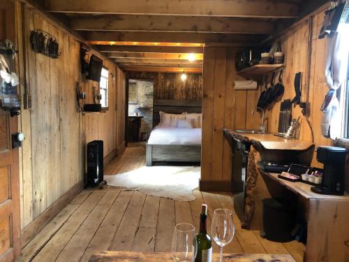 Double G Ranch & Guestlodge في مونتروز: غرفة بسرير في غرفة خشبية