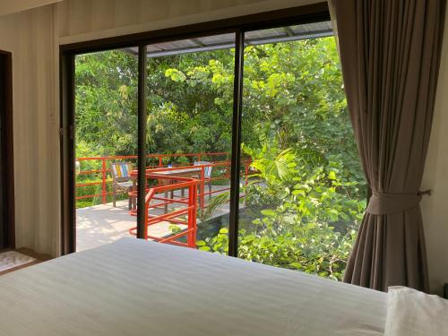 una camera con letto e vista su un balcone di HiddenBOX a Nakhon Nayok