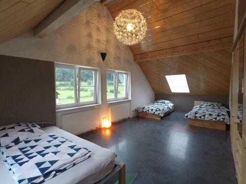 Schlafzimmer im Dachgeschoss mit 2 Betten und einem Kronleuchter in der Unterkunft Ferienwohnung Leutkirch offen hell hoch schöne Aussicht in Leutkirch im Allgäu