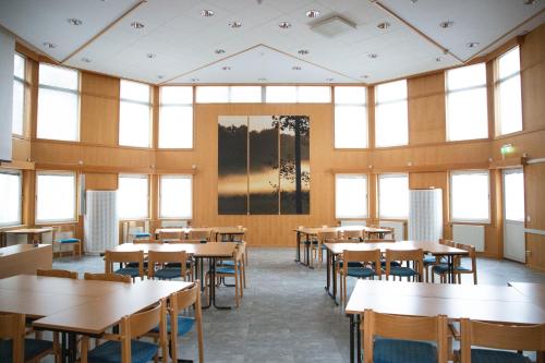 a classroom with tables and chairs and windows at Stiftsgården Vårdnäs Hotell in Brokind