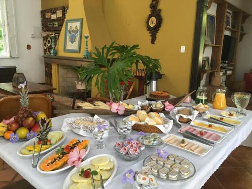 una mesa larga con un buffet de comida. en Pousada Villa Agrifoglio en Praia do Rosa