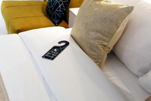 un cuscino su un letto con un cartellino nero sopra di NOX Waterloo a Londra