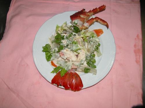 a plate of food with a salad on a pink table at Hotel Olympic in Saint Vincent