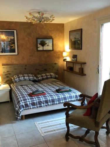 a bedroom with a bed and a chair at Une envie de montagne in Guillestre