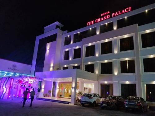a building with cars parked outside of it at night at the grand palace in Sāgar