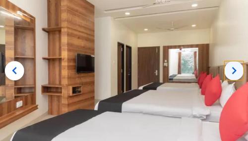 a hotel room with two beds and a tv at the grand palace in Sāgar