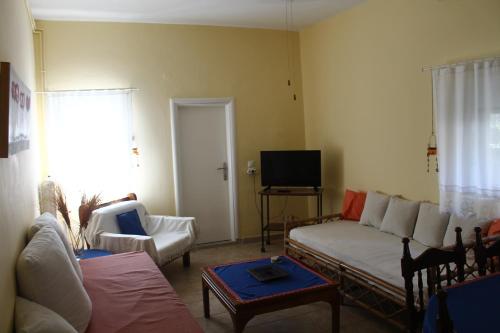 un soggiorno con un divano e una TV di Nona's Guest House Corfu Βenitses a Benitses