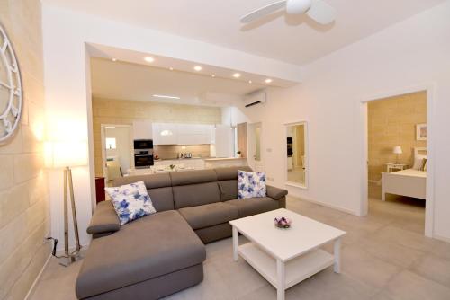 a living room with a couch and a table at Luxury Maisonette in Vittoriosa