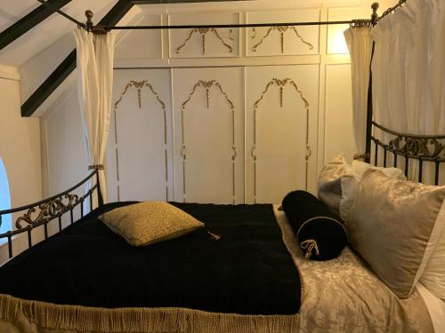 - une chambre avec un lit noir et blanc et des oreillers dans l'établissement Cobweb Hall, à Okehampton