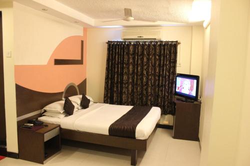 a hotel room with a bed and a television at Hotel Fortune in Mumbai