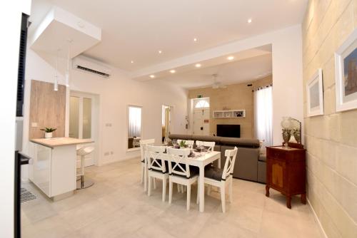 a kitchen and dining room with a white table and chairs at Luxury Maisonette in Vittoriosa