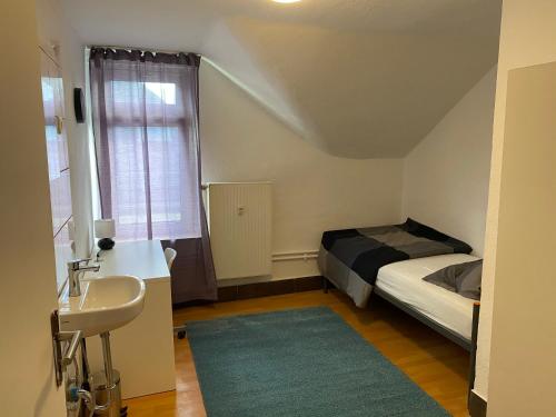Dormitorio pequeño con cama y lavamanos en Hotel am Schloss en Frankfurt