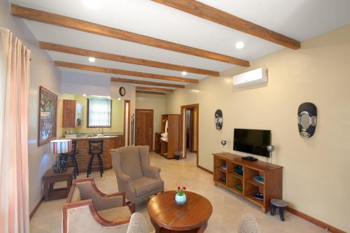 uma sala de estar com uma televisão e uma mesa em Airport Planet Lodge em Kingori