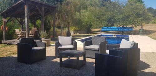 un groupe de chaises assises à côté d'une piscine dans l'établissement Cottage, à La Châtaigneraie