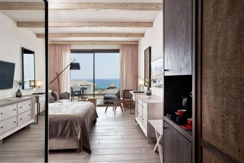 a hotel room with a bed and a view of the ocean at Mare Ayia Napa in Ayia Napa