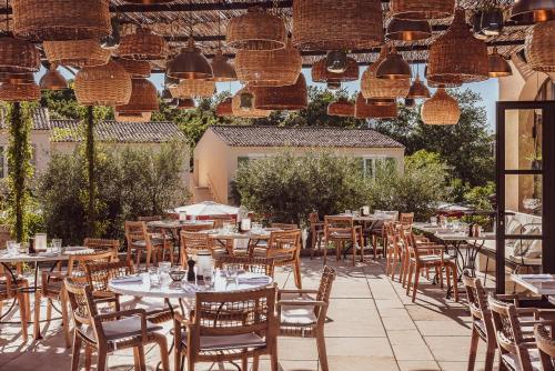 an outdoor restaurant with tables and chairs and lights at Hotel Lou Pinet in Saint-Tropez