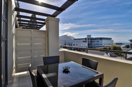 a patio with a table and chairs on a balcony at Whale Coast All-Suite-Hotel - DCC Hotel Group in Hermanus