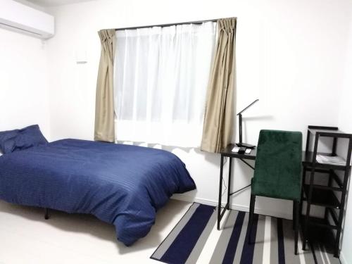 a bedroom with a bed and a desk and a chair at クレアゲハウス新百合ケ丘 in Kawasaki