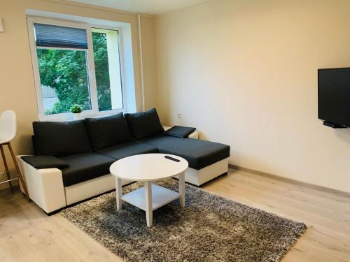 a living room with a black couch and a table at Sepa Apartment in Valga