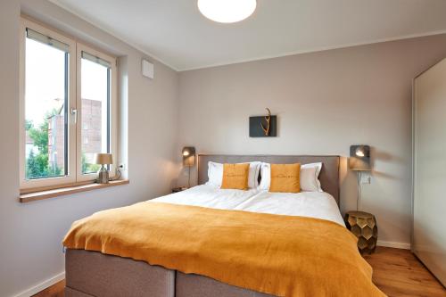 ein Schlafzimmer mit einem großen Bett und einer gelben Decke in der Unterkunft Suites MITTE - Aparthotel in Eisenach