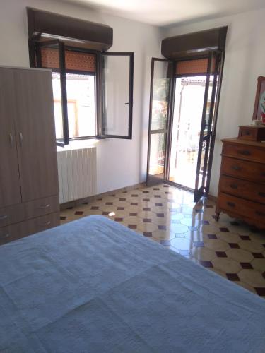 a bedroom with a bed and a dresser and windows at Galatro Terme House in Galatro
