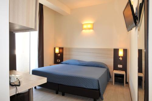 ペスキチにあるMorcavallo Hotel & Wellnessのベッドルーム(青いベッド1台、薄型テレビ付)