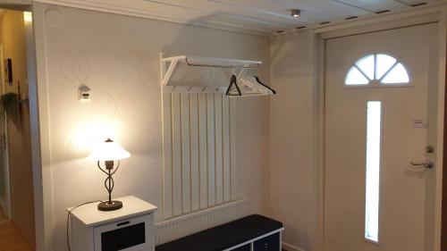 ein Zimmer mit einer Lampe auf einem Tisch neben einer Tür in der Unterkunft Villa Norrland in Vidsel