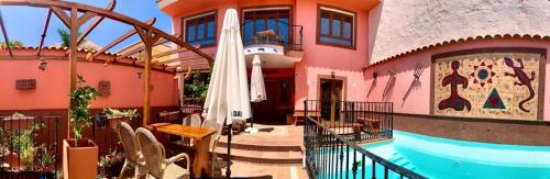 a house with a pool in front of a building at La Casona Canaria Boutique Home B & B in Agüimes